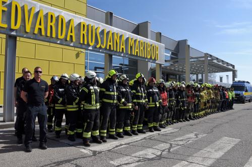 Udeleženci vaje v štirih vrstah stojijo pred letališčem Edvarda Rusjana Maribor.